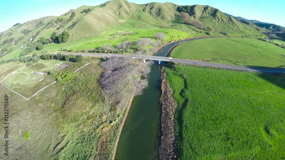 Aerial view of bridge over river pulling back to beach and ocean, near Gisborne, New Zealand