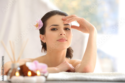 Young woman with flower relaxing in spa center
