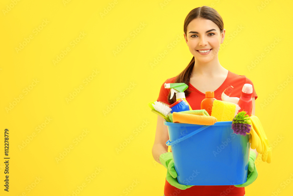Female cleaner on yellow background Female cleaner on yellow background