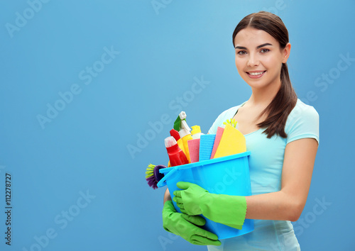 Female cleaner on blue background photo
