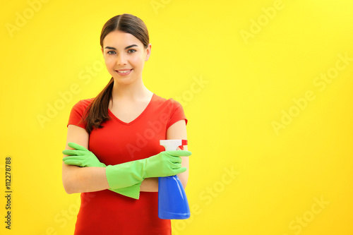 Female cleaner on yellow background