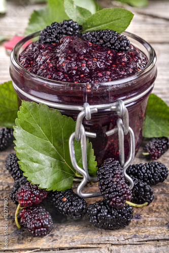 Domestic fresh mulberry jam on a rustic wooden board photo