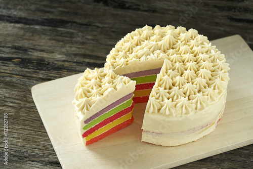 Colorful butter cream cake on wood plate slice