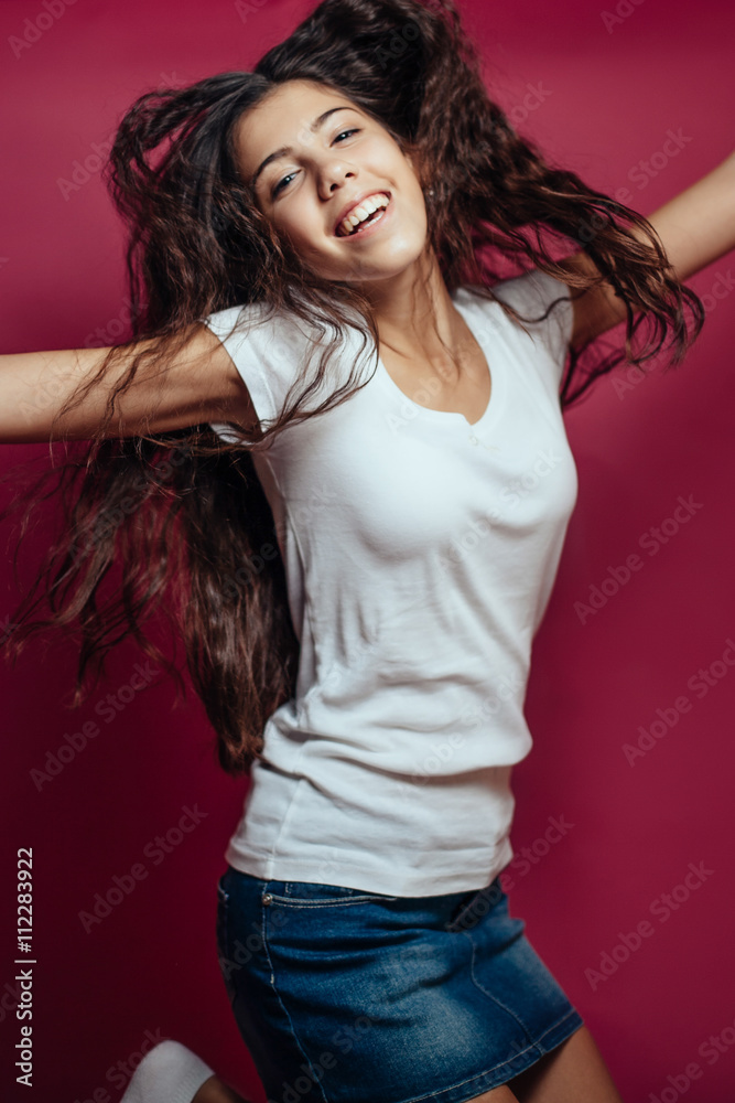 Smiling girl with brunette hair on red background.studio portrai Smiling girl with brunette hair on red background.studio portrai