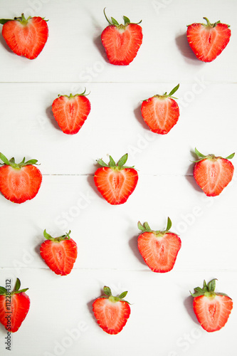 Fototapeta Naklejka Na Ścianę i Meble -  Sliced strawberry on white wooden background with copyspace. Healthy food concept. Fresh summer background.