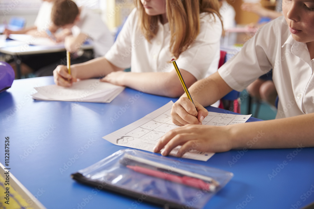 Two primary school kids working in class, close crop Two primary school kids working in class, close crop