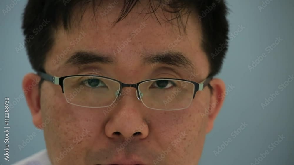 Close up of businessman adjusting glasses and looking at the camera