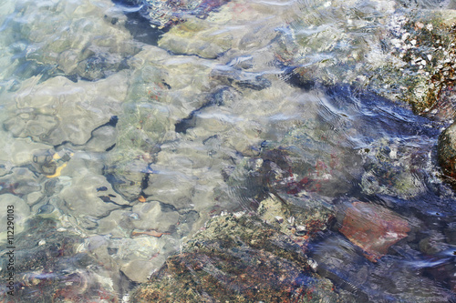 Small stones on the beach under the water surface