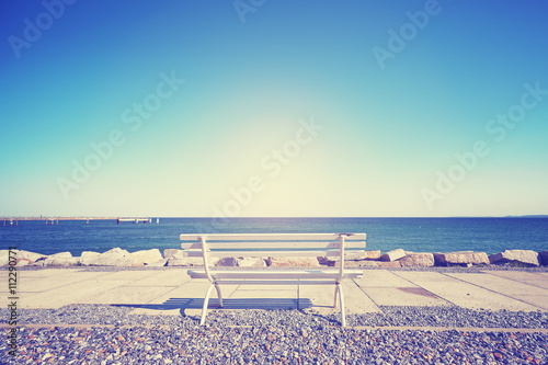 Vintage toned empty bench against the sun  space for text.