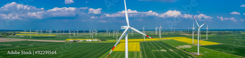 Panorama Luftbild und Nahaufnahme einer Windenergieanlage in einem Windpark mit Rapsfeld
