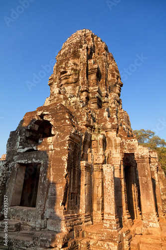 Stone carved face of Bayon Temple in Angkor Thom, Angkor district, Siem Reap, Cambodia. Full length view