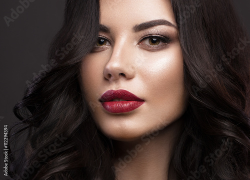 Fotografie Beautiful brunette model: curls, classic makeup and red lips