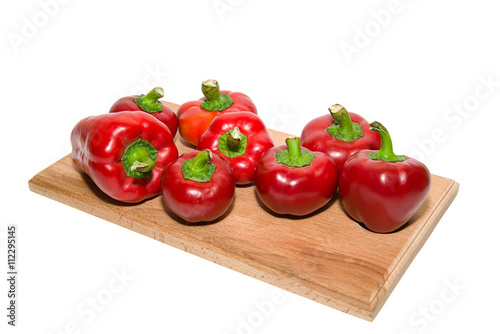 Several  peppers on a wooden cutting board. photo