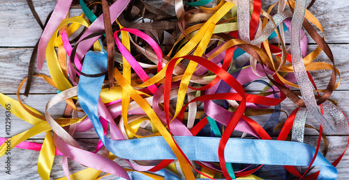 A lot of color ribbons on wooden background. Top view.