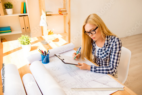 Smart girl writing in folder details of new plan