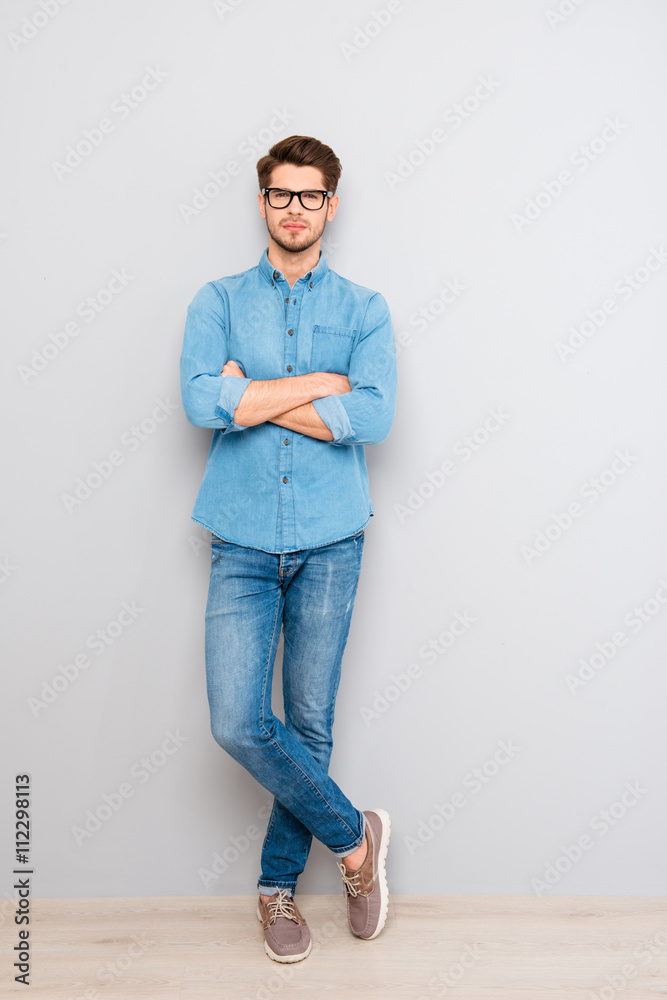 Full length portrait of  stylish man in glasses with crossed han