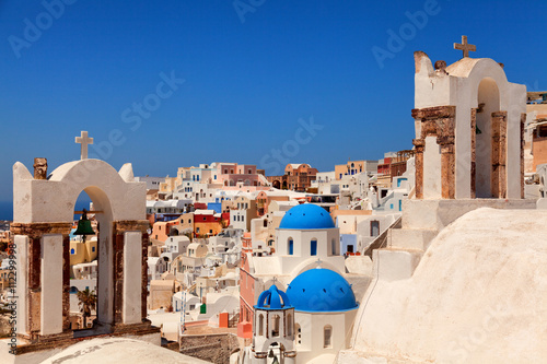 Landscape of Oia town, Santorini. Three blue domed churches and two bell towers on foreground