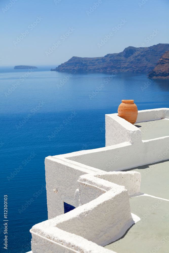 Fototapeta premium A perfect view of the volcano in Oia, Santorini with blue waters of the sea