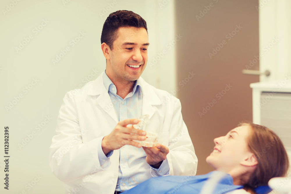 happy dentist showing jaw layout to patient girl happy dentist showing jaw layout to patient girl