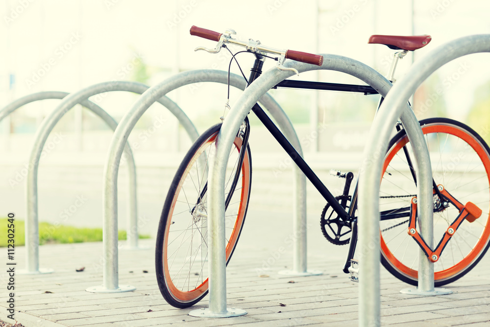 close up of bicycle locked at street parking