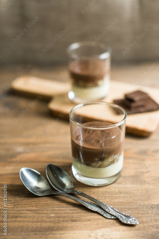 Obraz premium three-layered mousse dessert : chocolate , banana and vanilla