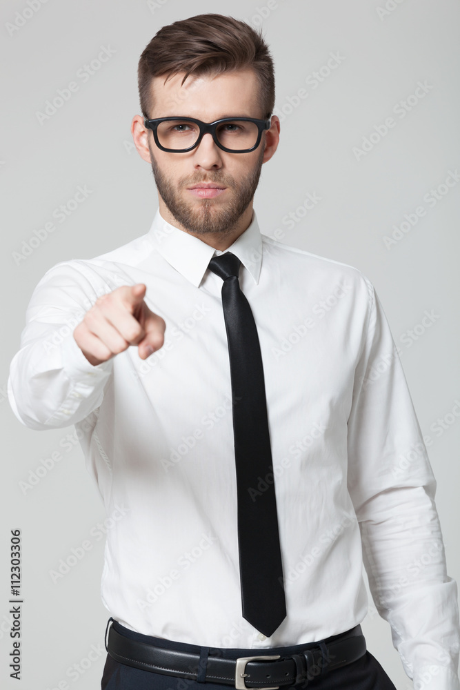 Young handsome businessman pointing at you isolated on gray bac Young handsome businessman pointing at you isolated on gray bac