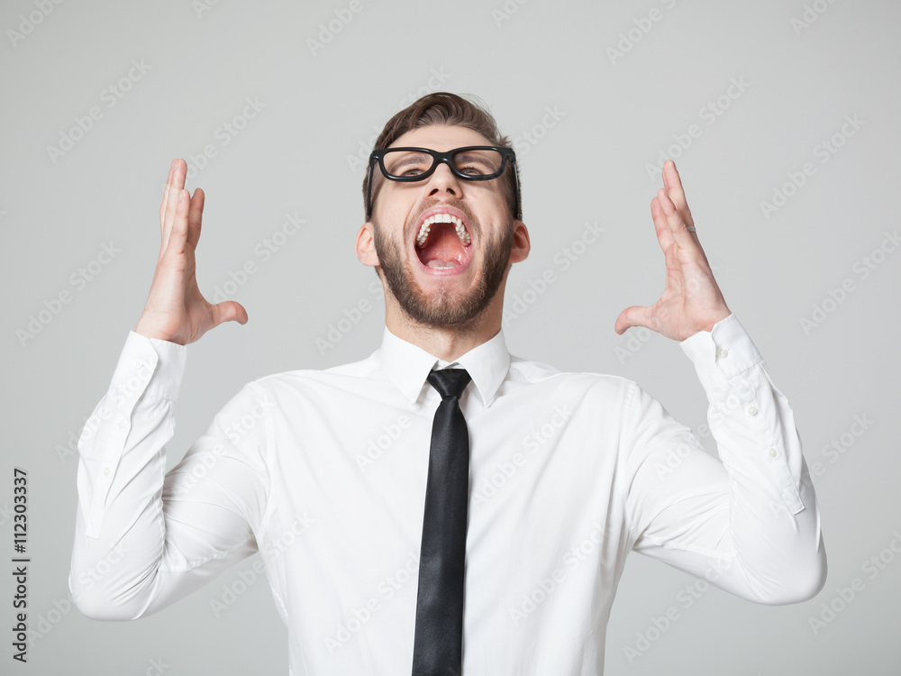 Young businessman screaming - isolated on gray background. Young businessman screaming - isolated on gray background.