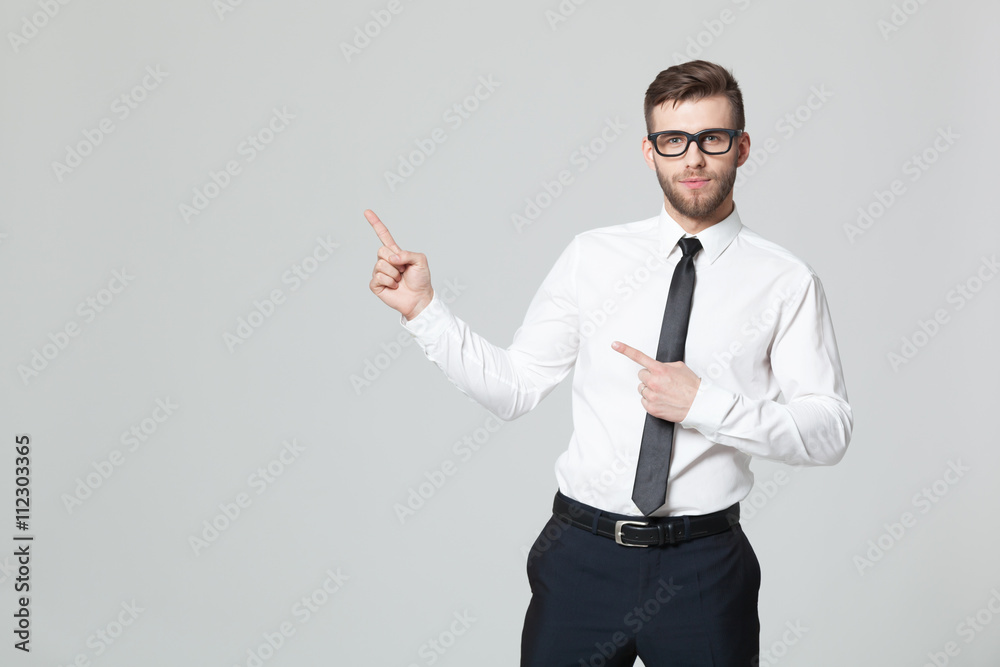 Handsome young businessman holding his arm up presenting copyspa Handsome young businessman holding his arm up presenting copyspa