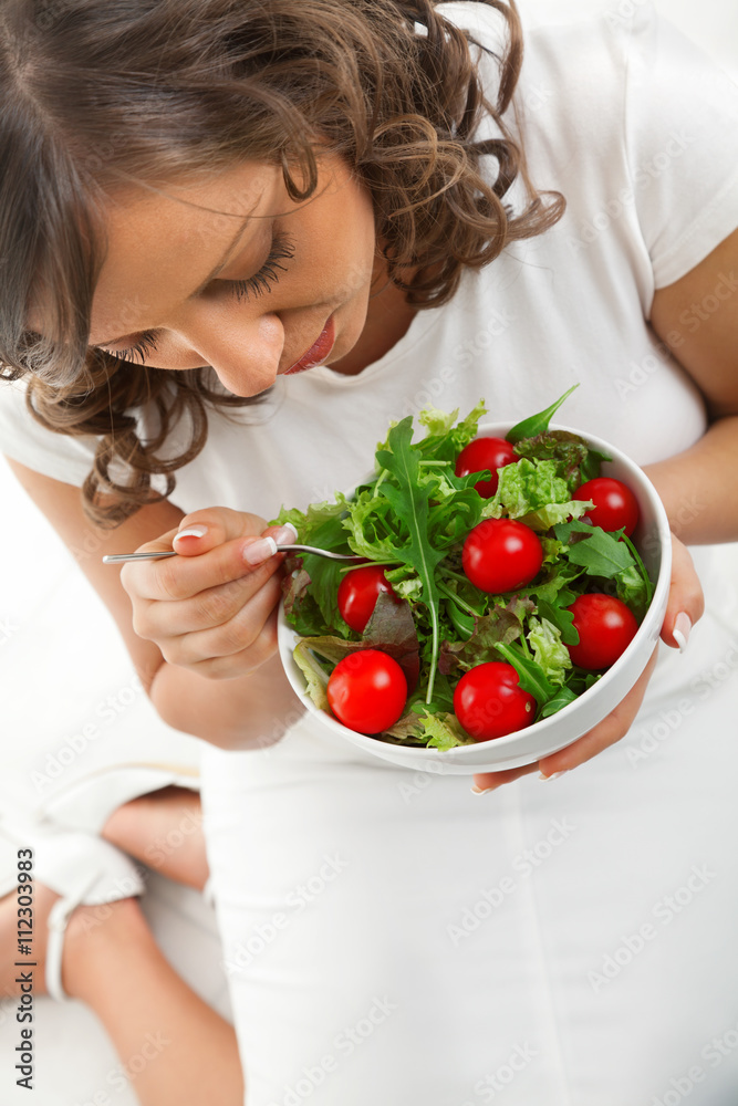 Young woman eating healthy salad. Wide angle, shot from above Young woman eating healthy salad. Wide angle, shot from above