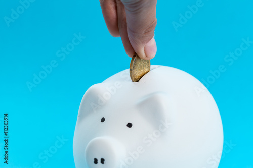 Inserting a coin into a piggy bank