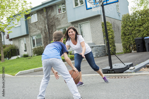 Happy family having fun outside with a basketball.