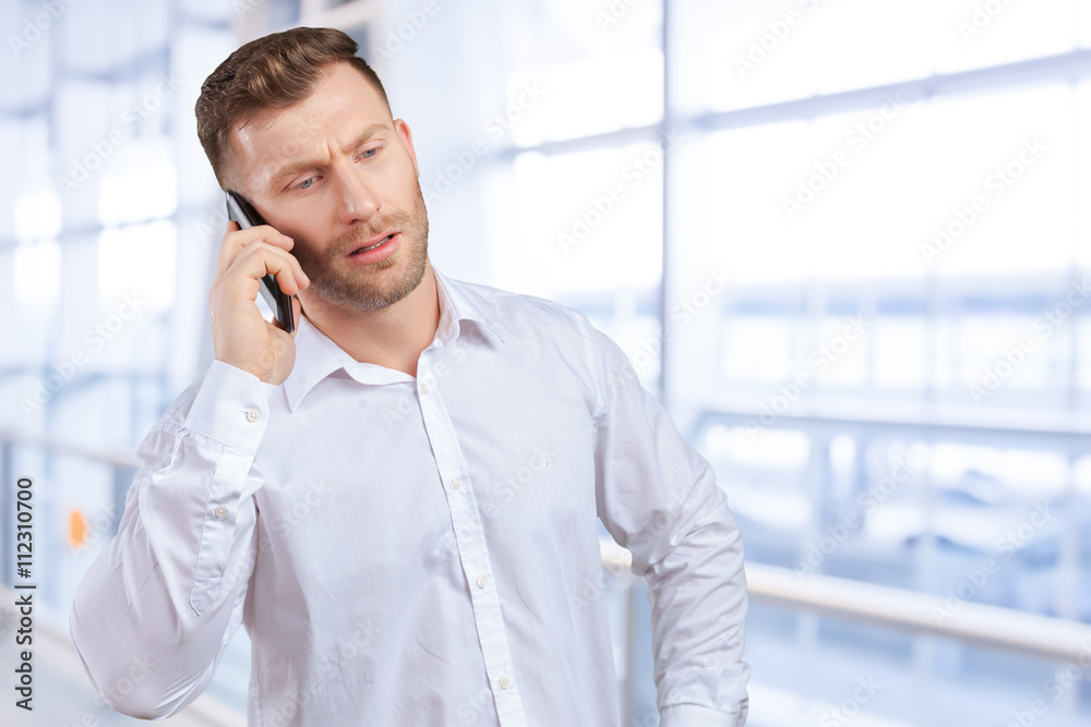 Handsome salesman talking on mobile phone Handsome salesman talking on mobile phone
