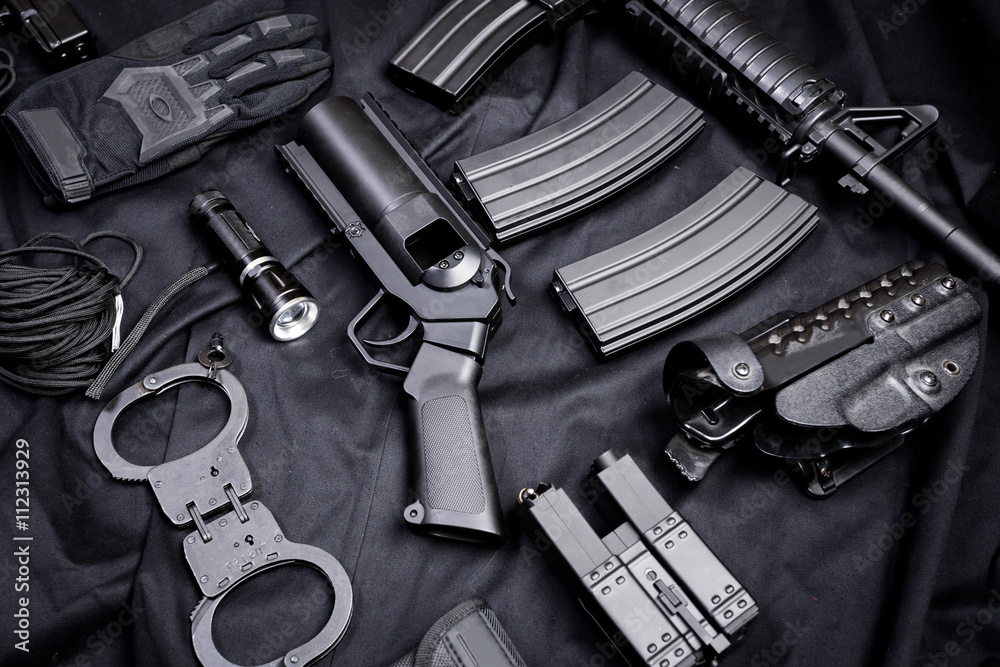 Rifle, gun, knife with sheath, compass and notebook with pen on on black cloth Rifle, gun, knife with sheath, compass and notebook with pen on on black cloth