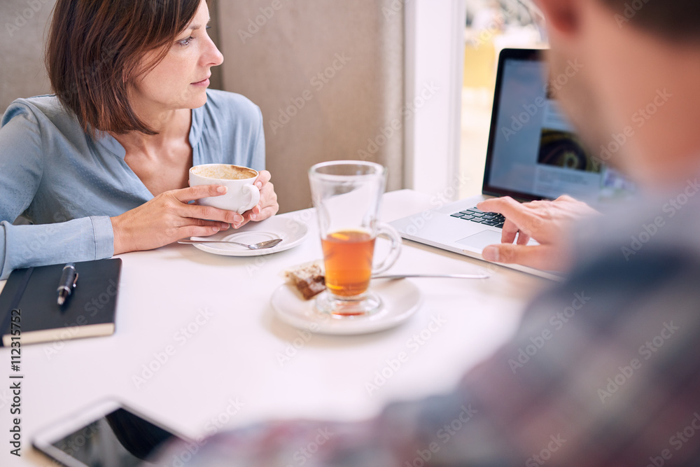 Tight shot of woman looking at laptop over mans shoulder Tight shot of woman looking at laptop over mans shoulder
