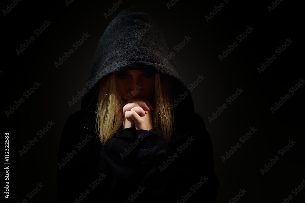 Praying woman in hood. Nun.