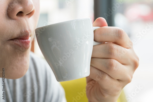 Beautiful young woman drinking coffee
 photo