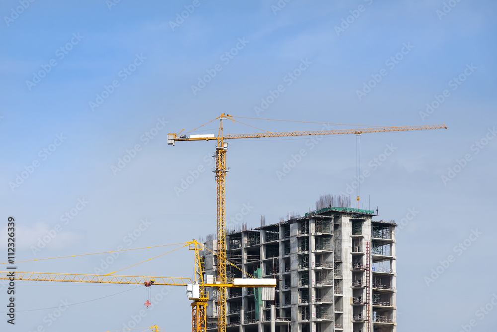 the construction site and crane with the blue sky,the under construction building site with the crane and blue sky the construction site and crane with the blue sky,the under construction building site with the crane and blue sky