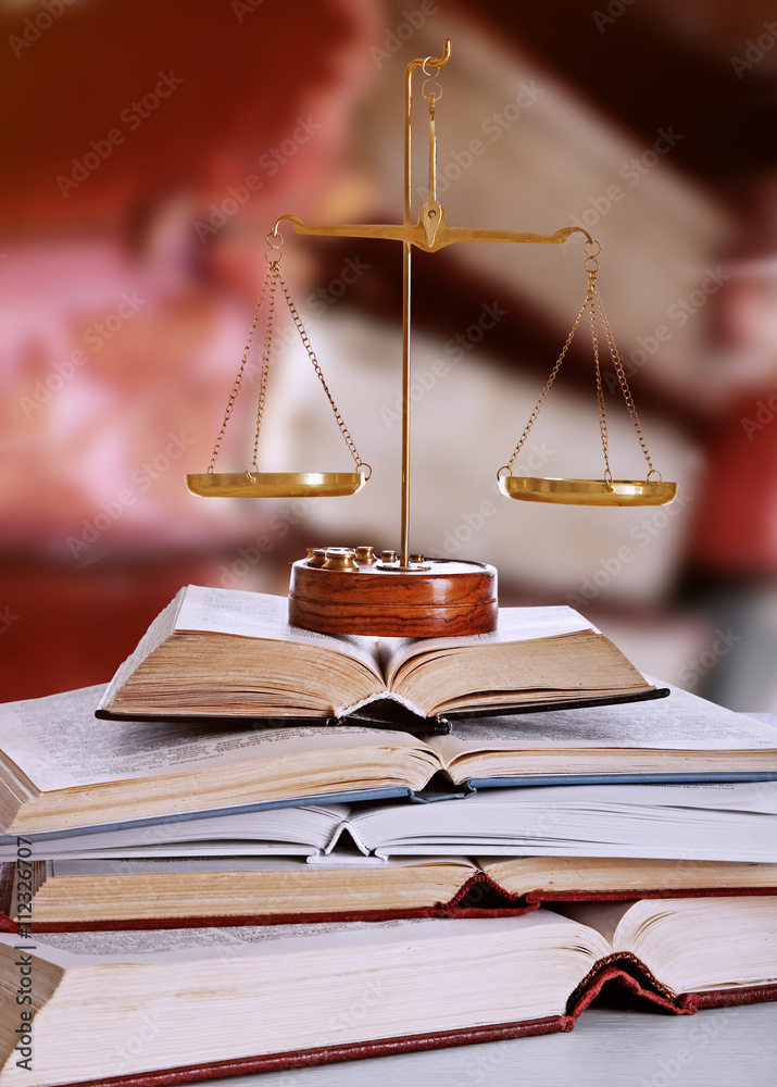 Justice scales with books on table in library Justice scales with books on table in library
