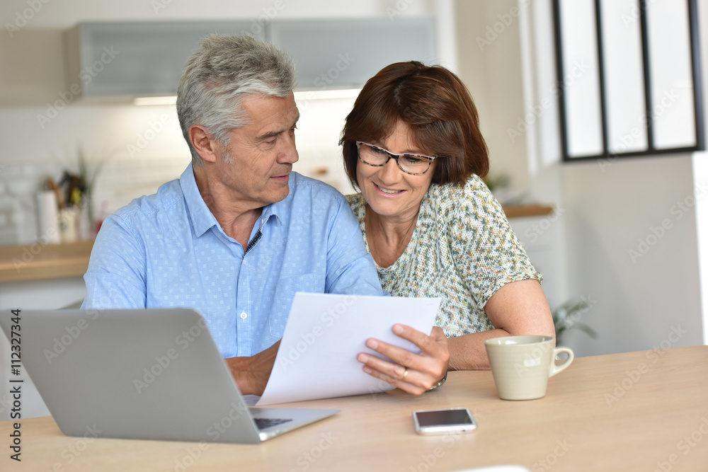 Senior couple using laptop computer at home