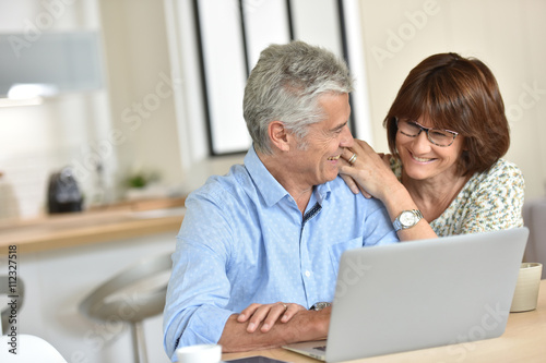 Senior couple using laptop computer at home