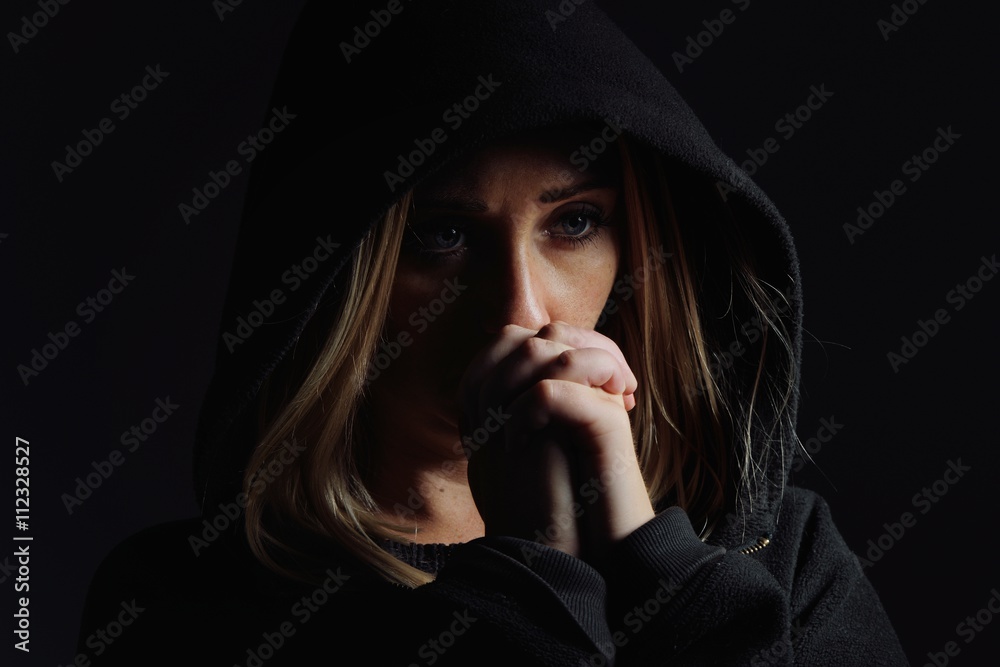 Praying woman in hood. Nun.