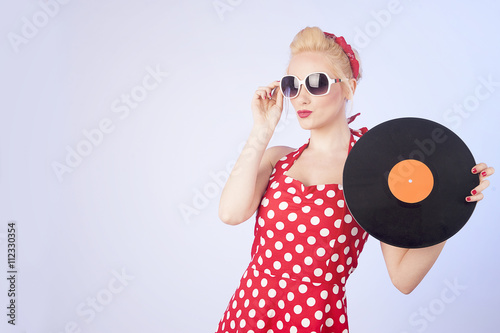 Fotografie Pin-up girl in vintage dress holding a vinyl record