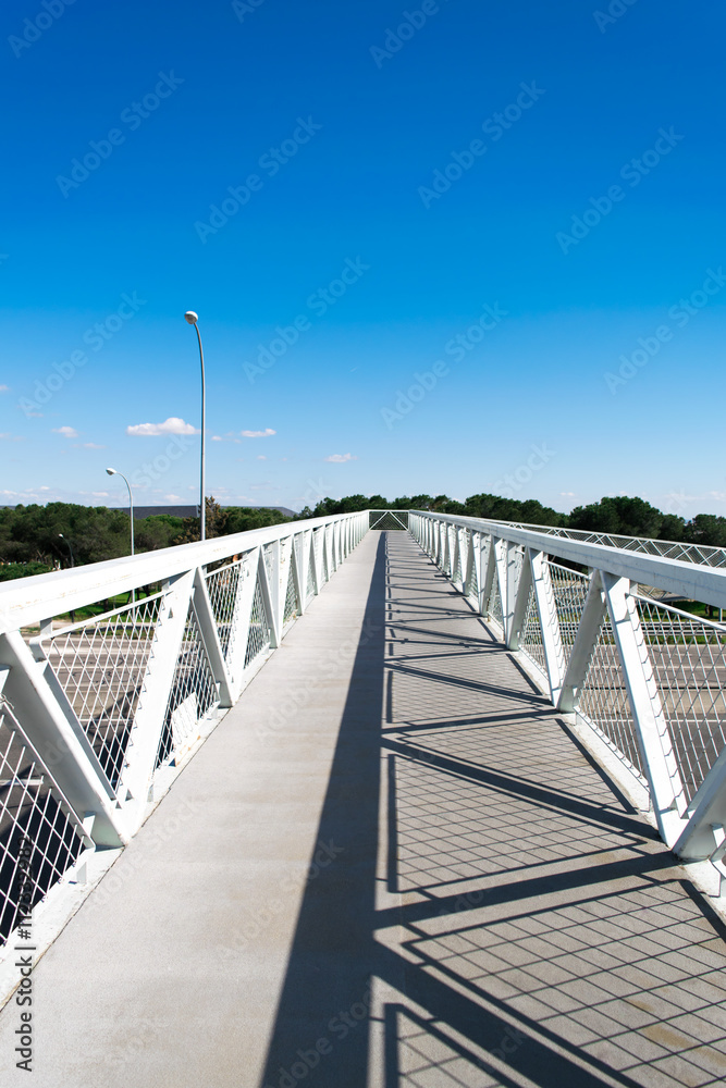 Metal footbridge. Geometric shadow created by the sunlight on a metal footbridge