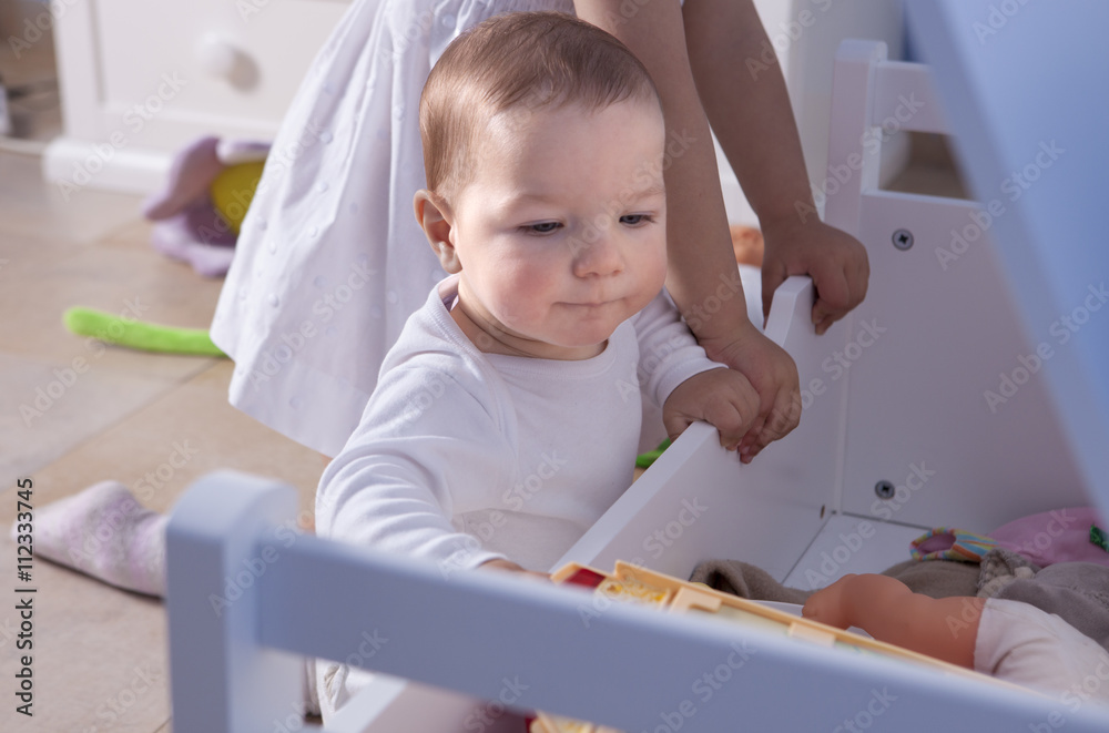 Baby boy playing with his sister at toys room Baby boy playing with his sister at toys room