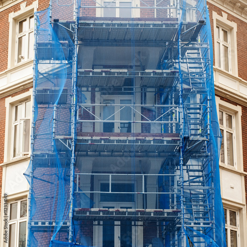 restoration facade of old house under blue net