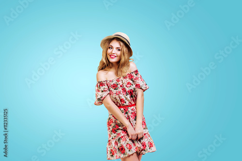 preety and happy young woman ( girl ) in hat smiling and shy on blue background