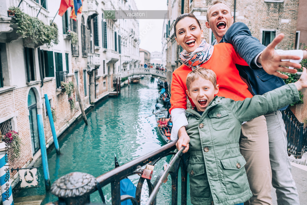 Happy family take a selfie photo on the one of bridge in Venice