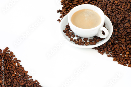 A cup of coffee with coffee beans on a white background