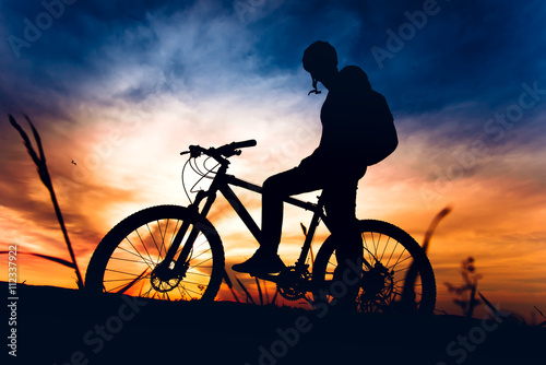 silhouette of biker riding mountain bike at sunset