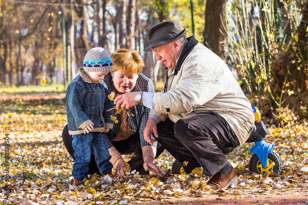 grandparents playing with grandson in a park grandparents playing with grandson in a park